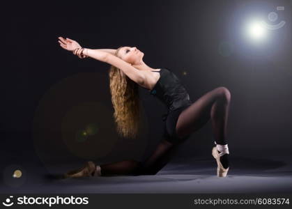 Ballerina dancing in the dark studio