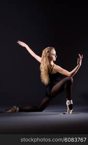 Ballerina dancing in the dark studio