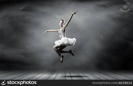 Ballerina girl. Young pretty ballerina girl making jump in dance
