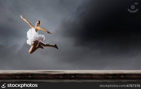 Ballerina girl. Young pretty ballerina girl making jump in dance