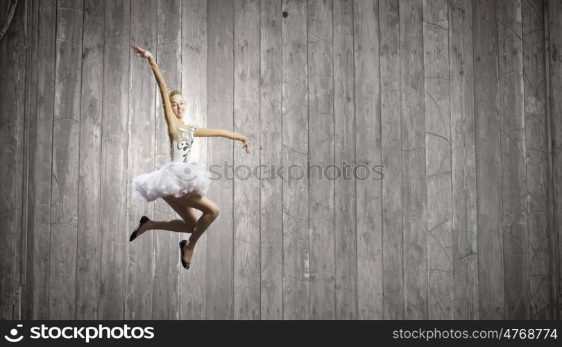 Ballerina girl. Young pretty ballerina girl making jump in dance