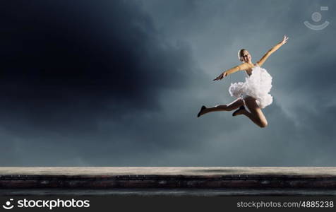 Ballerina girl. Young pretty ballerina girl making jump in dance