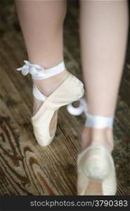 Ballerina legs on tiptoe wearing ballet shoes