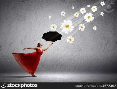 Ballet dancer in flying satin dress with umbrella. ballet dancer in flying satin dress with umbrella and flowers