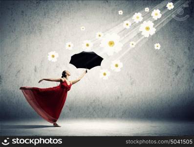 Ballet dancer in flying satin dress with umbrella. ballet dancer in flying satin dress with umbrella and flowers