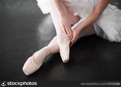 Ballet dancer legs in pointe shoes closeup. Ballerina rehearsal in class. Ballet dancer legs in pointe shoes closeup