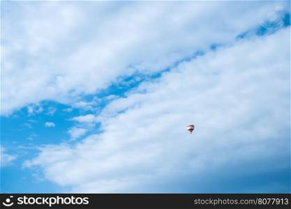 Balloon in the blue cloudy sky