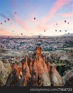 Balloons over the rocks of Cappadocia in the early morning. Pink dawn. Goreme, Turkey. Trade marks removed. Balloons over rocks of Cappadocia in early morning