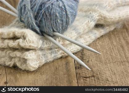 balls of yarn and mittens on a wooden background