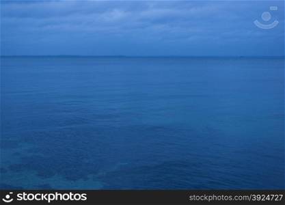 Baltic sea at night. The calm surface of the baltic sea at night with clouds and a blue cast