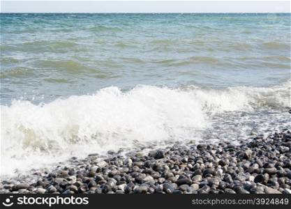 Baltic sea on a coast with pebble stones. Wave on the beach of the baltic sea on a coast with pebble stones