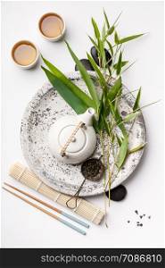 Bamboo branches and green tea on white background, asian food concept, flat lay