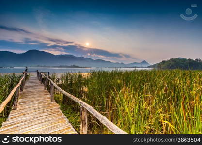 Bamboo bridge near reservoir with mountain and sky view in Kanchanaburi,Thailand