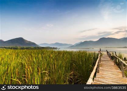 Bamboo bridge near reservoir with mountain and sky view in Kanchanaburi,Thailand
