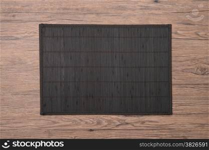 Bamboo place mat on wooden deck table.