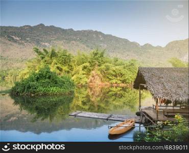 Bamboo raft in river with tree and mountain and blue sky in morning,Thailand
