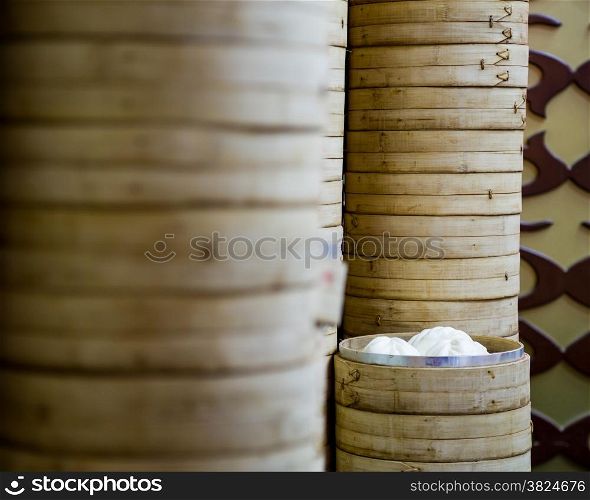 Bamboo rice steamers stacked with one open showing steamed buns