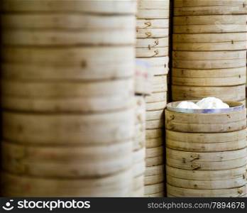 Bamboo rice steamers stacked with one open showing steamed buns