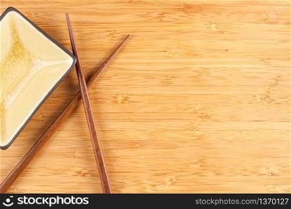 Bamboo Textured Surface Background with Chop Sticks and Bowl and Plenty of Room For Text.