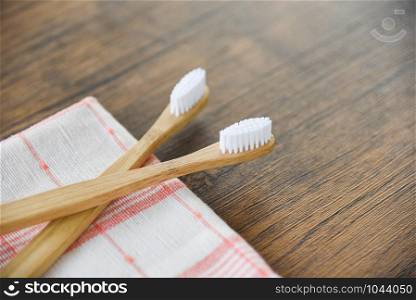 Bamboo toothbrush on the fabric eco natural plastic free items on rustic background