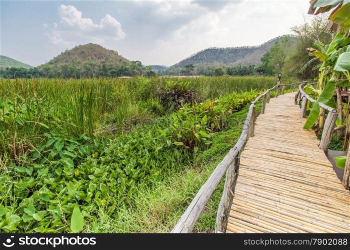 Bammboo bridge near reservoir with mountain and sky view in Karnchanaburi,Thailand