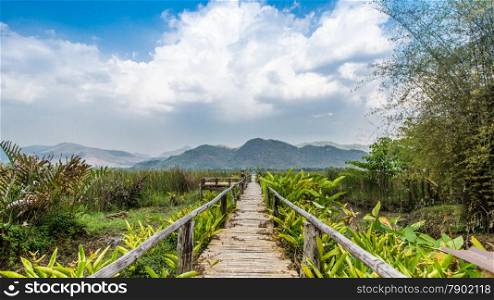 Bammboo bridge near reservoir with mountain and sky view in Karnchanaburi,Thailand