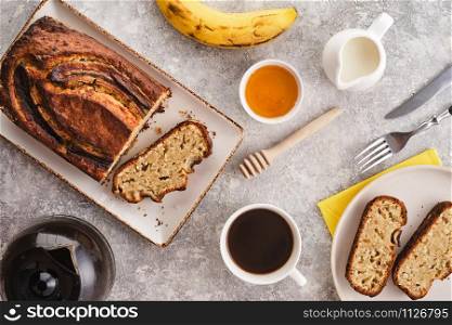 Banana bread. Freshly baked homemade banana pie with honey and butter on a light gray background. View from above.