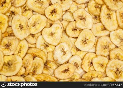 Banana chips, dehydrated slices of fresh ripe bananas as food background. . Banana chips for background