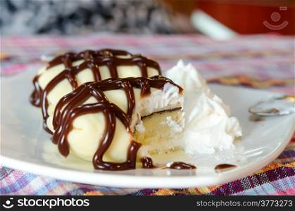 banana crepe rolls filled with white cream and banana, topping with chocolate syrup served with whipping cream