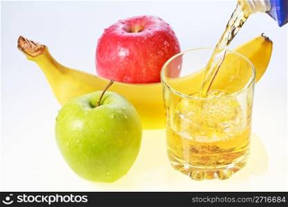 Banana, green and red apples and glass filling with apple juice