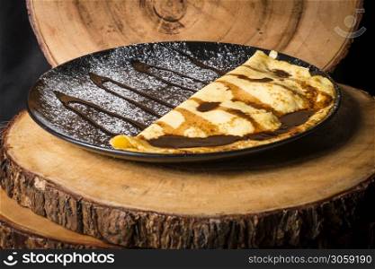 Banana pancake with chocolate sauce and icing sugar