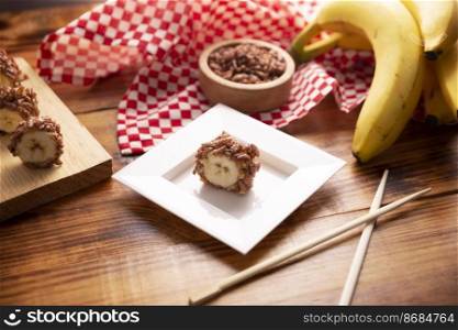 Banana sushi sweet rolls with caramel, peanut butter and chocolate puffed rice. Funny and easy homemade snack for kids and adults.