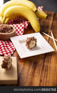 Banana sushi sweet rolls with caramel, peanut butter and chocolate puffed rice. Funny and easy homemade snack for kids and adults.