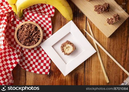 Banana sushi sweet rolls with caramel, peanut butter and chocolate puffed rice. Funny and easy homemade snack for kids and adults.