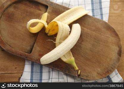 banana with its peel on an old cutting board