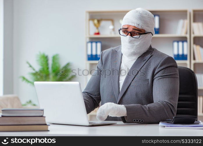 Bandaged businessman worker working in the office doing paperwor. Bandaged businessman worker working in the office doing paperwork