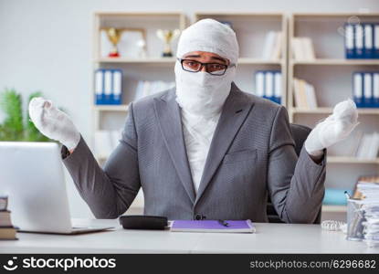 Bandaged businessman worker working in the office doing paperwor. Bandaged businessman worker working in the office doing paperwork