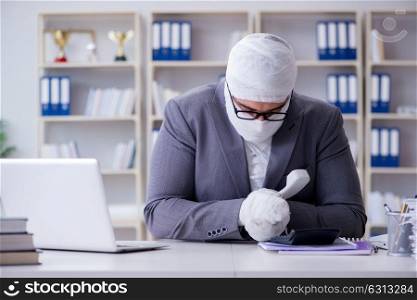 Bandaged businessman worker working in the office doing paperwor. Bandaged businessman worker working in the office doing paperwork