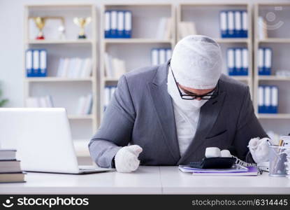 Bandaged businessman worker working in the office doing paperwor. Bandaged businessman worker working in the office doing paperwork