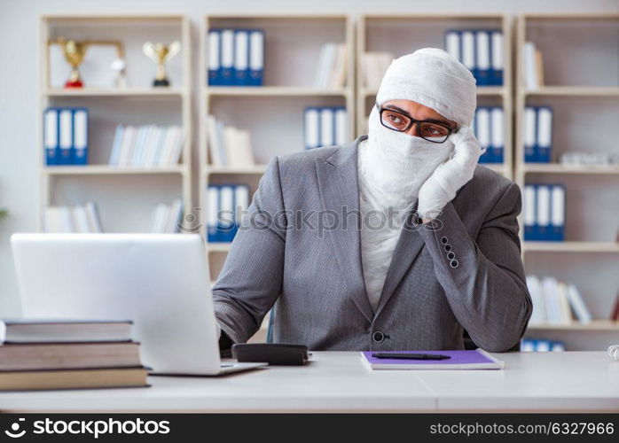 Bandaged businessman worker working in the office doing paperwor. Bandaged businessman worker working in the office doing paperwork