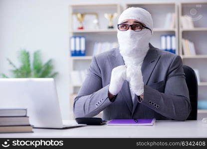 Bandaged businessman worker working in the office doing paperwor. Bandaged businessman worker working in the office doing paperwork