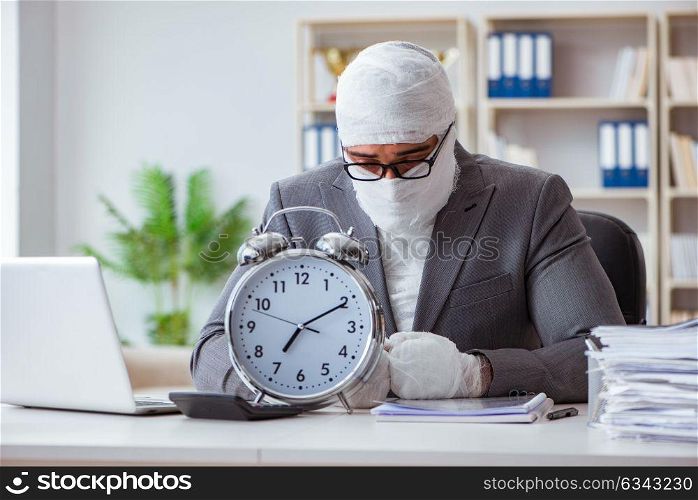 Bandaged businessman worker working in the office doing paperwor. Bandaged businessman worker working in the office doing paperwork