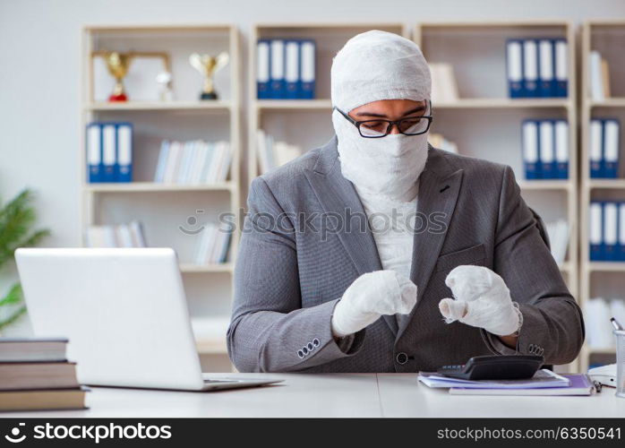 Bandaged businessman worker working in the office doing paperwor. Bandaged businessman worker working in the office doing paperwork