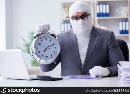 Bandaged businessman worker working in the office doing paperwor. Bandaged businessman worker working in the office doing paperwork