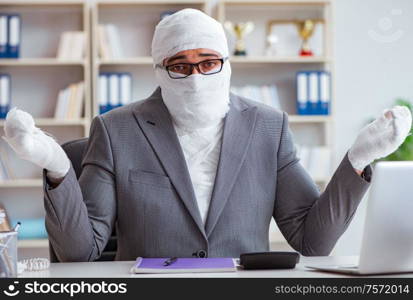 Bandaged businessman worker working in the office doing paperwork. Bandaged businessman worker working in the office doing paperwor