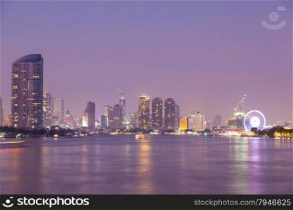 Bangkok city at night. Building a skyscraper lit A river through the city