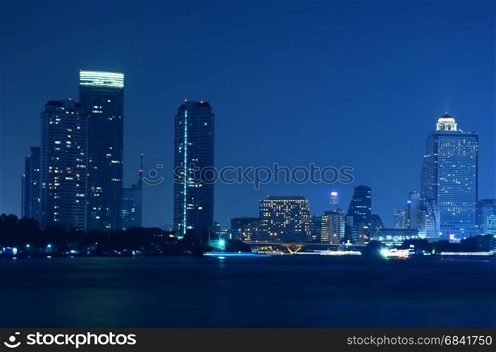 bangkok city skyline from the Chao Phraya River by night with Light passing
