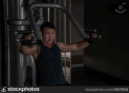 Bangkok, Thailand 06 Oct 2019 : A strong male bodybuilder, The power to train muscles with a lifting weights on an exercising machine in gym or fitness club. copy space.