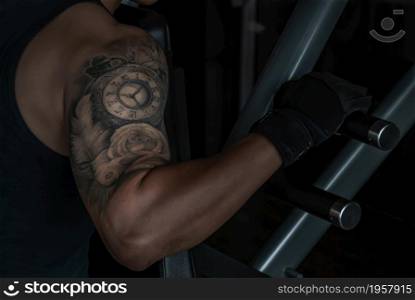 Bangkok, Thailand 06 Oct 2019 : Closeup of strong male bodybuilder, The power to train muscles with a lifting weights on an exercising machine in gym or fitness club.