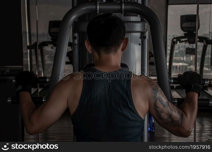 Bangkok, Thailand 06 Oct 2019 : The back of strong male bodybuilder, The power to train muscles with a lifting weights on an exercising machine in gym or fitness club.